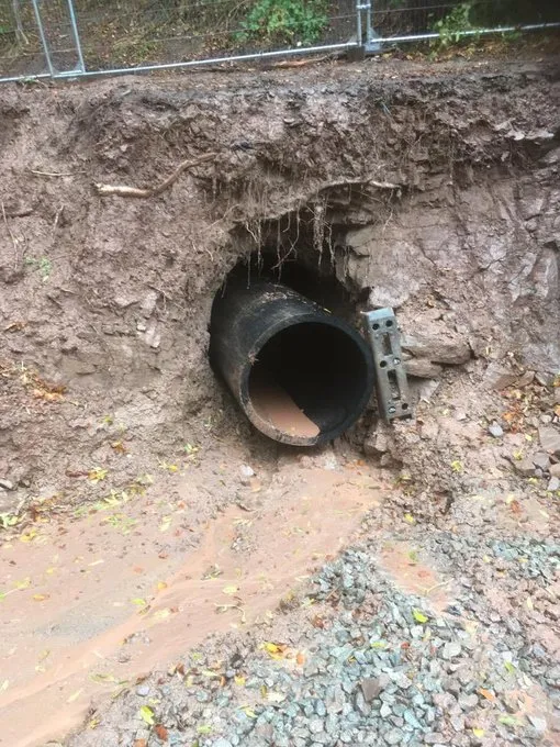The finished 900mm outfall pipe emerging from the rock face at Hopton, with water already running through it